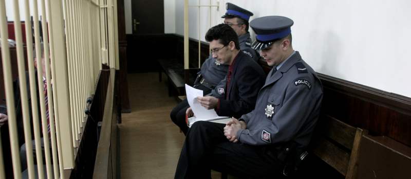 Krystian Bala guardato a vista dalla polizia durante il suo processo per omicidio - Immagine utilizzata per uso di critica o di discussione ex articolo 70 comma 1 della legge 22 aprile 1941 n. 633, fonte Internet